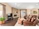 Cozy living room with a stone fireplace, leather furniture, and large window at 11807 E Clinton St, Scottsdale, AZ 85259
