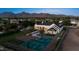 Aerial view of a large estate with a pool, basketball court, lush landscaping, and mountain views at 12240 N 98Th St, Scottsdale, AZ 85260