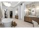 Bright bathroom featuring a soaking tub, dual vanities, and a spacious walk-in closet at 12240 N 98Th St, Scottsdale, AZ 85260