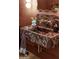 Stylish bathroom featuring a red marble sink, gold faucet, and unique design details at 12240 N 98Th St, Scottsdale, AZ 85260