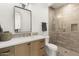 Modern bathroom with a wood vanity, framed mirror, and glass-enclosed shower with stylish tiles at 12240 N 98Th St, Scottsdale, AZ 85260