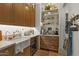 Butler's pantry with marble countertops, custom cabinets, open shelving, and a beverage cooler at 12240 N 98Th St, Scottsdale, AZ 85260