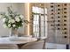 This stunning dining room features a gorgeous lit custom wine cellar and designer furnishings at 12240 N 98Th St, Scottsdale, AZ 85260