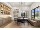 Dining area with a modern table, banquette seating, elegant lighting, and hardwood floors at 12240 N 98Th St, Scottsdale, AZ 85260
