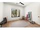 Bright exercise room featuring wood floors, a large window, and basic workout equipment at 12240 N 98Th St, Scottsdale, AZ 85260