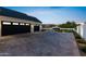 The home features a large black four-car garage, an expansive driveway, and manicured landscape at 12240 N 98Th St, Scottsdale, AZ 85260