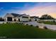 A lovely home boasts a large green lawn, exterior lights, a manicured landscape, and a black four car garage at 12240 N 98Th St, Scottsdale, AZ 85260