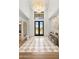 Elegant home foyer featuring a checkered tile floor, high ceilings and a striking chandelier at 12240 N 98Th St, Scottsdale, AZ 85260