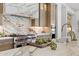 Gourmet kitchen featuring marble countertops and backsplash, Wolf range, and custom cabinetry at 12240 N 98Th St, Scottsdale, AZ 85260