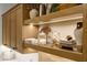 Well-organized laundry room with wood cabinets, open shelving, and stylish decor accents at 12240 N 98Th St, Scottsdale, AZ 85260