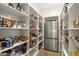 Organized pantry with ample shelving and a stainless steel refrigerator at 12240 N 98Th St, Scottsdale, AZ 85260