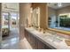 This bathroom boasts dual sinks, gorgeous lighting, and views into the ensuite water closet at 12311 E Black Rock Rd, Scottsdale, AZ 85255