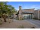 Contemporary home showcases desert landscaping, a stone chimney, and a sleek glass garage door at 12311 E Black Rock Rd, Scottsdale, AZ 85255