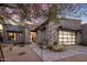 Contemporary home showcasing stone accents, desert landscaping, and a stylish glass garage door at 12311 E Black Rock Rd, Scottsdale, AZ 85255