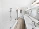 Bright bathroom with a large mirror, double sinks, a bathtub with a shower, and tile flooring at 12342 S Shoshoni Dr, Phoenix, AZ 85044