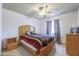 A comfortable bedroom with tile flooring, a ceiling fan, natural lighting and a wooden bed frame at 1285 E Mcmurray Blvd, Casa Grande, AZ 85122