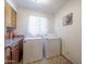 A laundry room with tile floors, wood cabinets, and a newer model washer and dryer at 1285 E Mcmurray Blvd, Casa Grande, AZ 85122