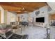 Open concept living room featuring vaulted wood ceilings, tile flooring, and a large black sofa at 1285 E Mcmurray Blvd, Casa Grande, AZ 85122