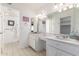 Bathroom featuring double sinks with decorative white cabinets and a large mirror at 1309 E Meadow Ln, Phoenix, AZ 85022
