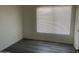 Clean and simple bedroom with new gray vinyl flooring and a sunlit window at 1452 E Emerald Ave, Mesa, AZ 85204