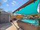 Backyard featuring a hot tub, shed, above ground pool, patio furniture and awning at 15203 N 153Rd Dr, Surprise, AZ 85379