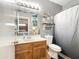 Gray nautical themed bathroom with wood vanity, decorative mirror, and shower with blue curtain at 15203 N 153Rd Dr, Surprise, AZ 85379