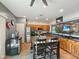 Well-lit kitchen with stainless steel appliances, wooden cabinets, kitchen island, and tile floors at 15203 N 153Rd Dr, Surprise, AZ 85379
