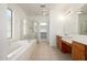 Bright bathroom features a soaking tub, tiled floor, and double sink vanity at 15469 W Dreyfus St, Surprise, AZ 85379