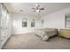 Spacious bedroom featuring neutral carpet, ceiling fan, and bright natural lighting at 15469 W Dreyfus St, Surprise, AZ 85379