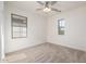 Bright bedroom features neutral carpet, a ceiling fan, and windows providing natural light at 15469 W Dreyfus St, Surprise, AZ 85379