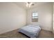This bedroom features carpeted floors, a bed, and a window providing natural light at 15469 W Dreyfus St, Surprise, AZ 85379