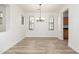 Bright dining room features neutral walls, wood laminate flooring, and modern chandelier at 15469 W Dreyfus St, Surprise, AZ 85379