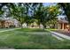 Spacious front yard with well-maintained lawn and mature trees, providing shade at 15469 W Dreyfus St, Surprise, AZ 85379