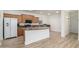 Open concept kitchen with breakfast bar, lots of cabinets, and wood laminate floors at 15469 W Dreyfus St, Surprise, AZ 85379