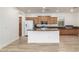 Open kitchen features a breakfast bar, modern appliances, and wood laminate flooring at 15469 W Dreyfus St, Surprise, AZ 85379
