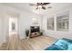 Bright living room featuring wood flooring, modern ceiling fan and large windows providing ample natural light at 15469 W Dreyfus St, Surprise, AZ 85379