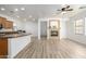 Open concept living space with a cozy fireplace, kitchen views, and wood laminate flooring at 15469 W Dreyfus St, Surprise, AZ 85379