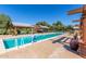 Large community pool with clear blue water, shaded pergola and lounge area at 15469 W Dreyfus St, Surprise, AZ 85379