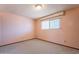 A cozy bedroom painted in soft pink with natural light from the window at 1654 E 2Nd St, Mesa, AZ 85203