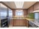 A kitchen featuring wood cabinets and vintage appliances, including a stainless steel refrigerator at 1654 E 2Nd St, Mesa, AZ 85203
