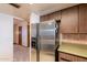 An angled view of a kitchen featuring a stainless steel refrigerator and dark wooden cabinets at 1654 E 2Nd St, Mesa, AZ 85203