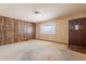 Cozy living room boasts wood paneled accent wall, neutral paint, and a plush carpet at 1654 E 2Nd St, Mesa, AZ 85203