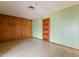 The living room with wood paneling, light green walls, linoleum floors and a wooden front door at 1654 E 2Nd St, Mesa, AZ 85203