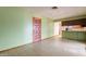 The home's living room has light green walls and linoleum floors and a wooden entry door at 1654 E 2Nd St, Mesa, AZ 85203