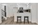 Bright kitchen featuring white cabinetry, stainless steel appliances, a breakfast bar, and stylish black barstools next to stairs at 1717 E Union Hills Dr # 1033, Phoenix, AZ 85024