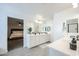 Spacious bathroom with dual vanity, white cabinets, and an adjacent bedroom at 18813 W Solano Dr, Litchfield Park, AZ 85340