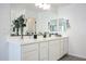 Bathroom with double sinks, white cabinetry, and a modern design at 18813 W Solano Dr, Litchfield Park, AZ 85340