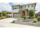 Two-story home featuring a two-car garage and a stone-accented entryway, complemented by a neatly landscaped front yard at 18813 W Solano Dr, Litchfield Park, AZ 85340