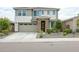 Charming two-story home with a stone-accented entryway, landscaped front yard, and attached two-car garage at 18813 W Solano Dr, Litchfield Park, AZ 85340