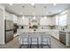 Bright white kitchen featuring granite countertops, an island with seating, and stainless steel appliances at 18813 W Solano Dr, Litchfield Park, AZ 85340